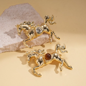 Golden horse brooches with sparkling rhinestones and brown gems on natural stone base