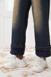 Dettaglio di jeans a vita alta con calda fodera in pile e finitura invecchiata