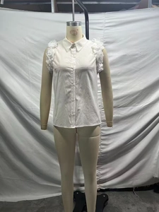 Detail of white sleeveless shirt featuring lapel collar and 3D floral appliques on shoulders