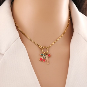 Détail du collier cerise doré avec pendentif Amour et gemme rouge sur le cou