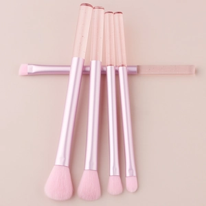 Detailed flat lay of 5-piece pink crystal handle makeup brush set on soft pink background