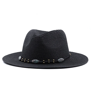 Detail of black straw fedora hat featuring vintage woven rope and bronze metal emblems