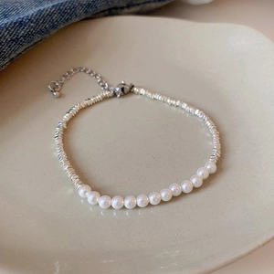 Vue détaillée du bracelet épissure de perles et billes argentées sur une assiette blanche
