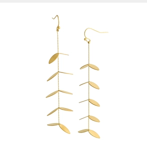 Dettaglio macro delle nappe a foglia d'oro stratificate su orecchini pendenti chic