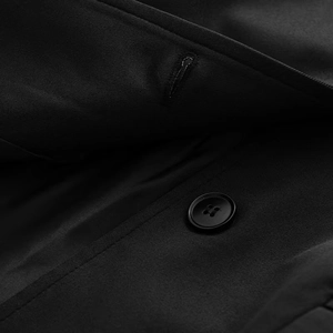 Detailed close-up of button and buttonhole on black slim-fit blazer for women