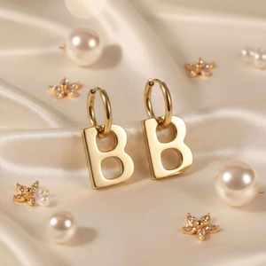 Luxury gold letter B drop earrings for women on champagne silk with pearls