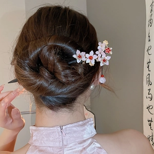 Close-up of butterfly floral hair pin with red bead tassel on a traditional updo