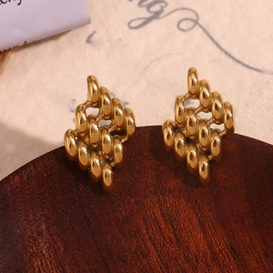 Detailed close-up of 18K gold plated geometric woven earrings on a wooden stand