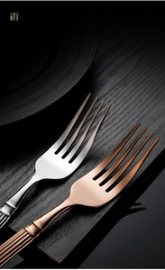 Close-up of golden stainless steel forks featuring vintage Roman column texture handles