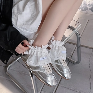 Silver metallic trainers with white lace ruffle socks styled in balletcore fashion aesthetic