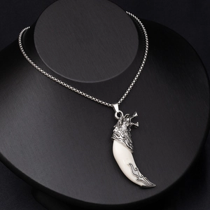 Detailed close-up of retro wolf fang pendant on silver box chain for men's fashion