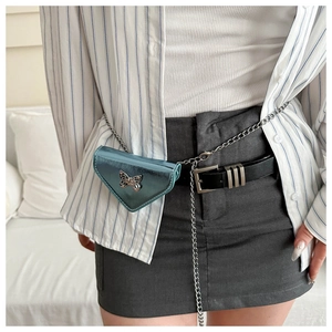 Détail du sac bandoulière bleu métallisé avec boucle papillon et chaîne en argent