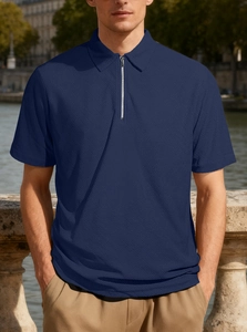 Detail view of navy blue waffle knit fabric and half-zip collar on men's polo shirt