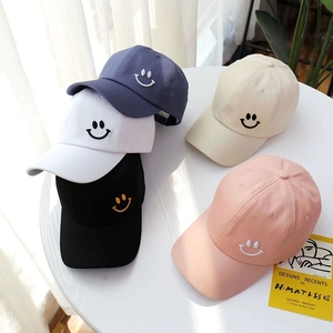 Group of minimalist cotton baseball caps with embroidered smiley faces in five colors