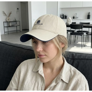 Detail of beige baseball cap with navy embroidery and stylish American casual design