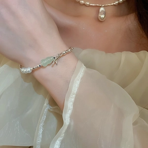 Détail du bracelet en perles d'eau douce avec pendentifs jade vert et bambou au poignet