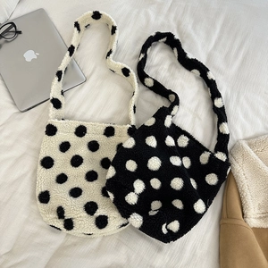 Close-up of plush fleece tote bags in cream and black polka dots for autumn and winter