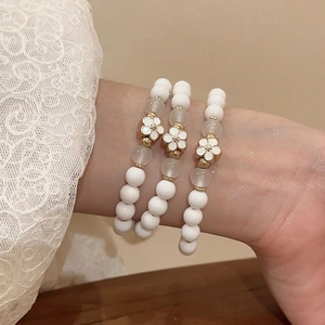 Three-piece acrylic beaded flower bracelet set with white petals and golden accents