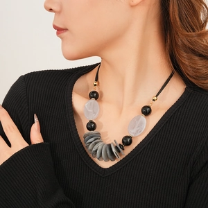Detail of a vintage layered oval pendant necklace with resin beads on a black cord
