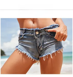 Nahaufnahme von distressed Denim-Shorts mit Fransen am sonnigen Strand