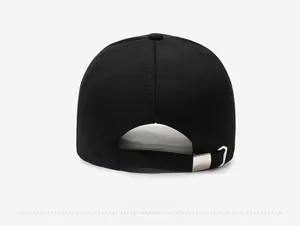 Detail view of the adjustable silver metal buckle on the back of a black baseball cap