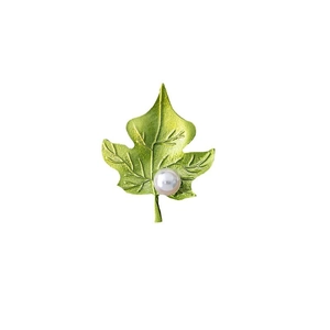 Exquisite green enamel leaf brooch with pearl accent and metallic texture on white background