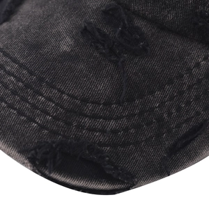 Detailed macro view of washed black baseball cap brim with distressed holes and stitching