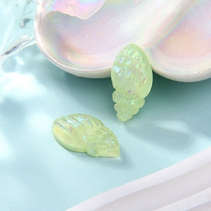 Macro view of translucent green resin conch shells with a pearlescent finish for DIY crafts
