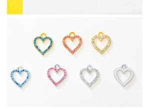 Detailed view of DIY heart pendants with colorful rhinestones and pearls in gold and silver