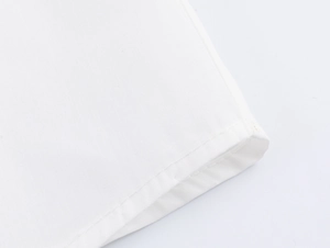 Detailed close-up of double-stitched cuff on a white woven shirt with premium finishing