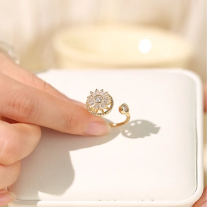 Adjustable gold sunflower ring with sparkling zircons worn by a model in natural light