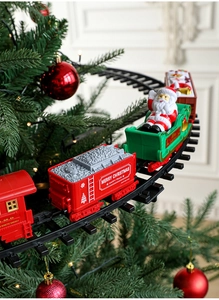 Close-up of electric Christmas train circling a decorated tree with Santa figurine