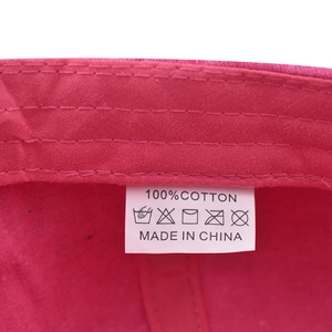 Detailed macro shot of the cotton care label and internal stitching on the pink baseball cap