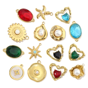 Detailed flat lay of assorted gold-plated stainless steel charms with colorful gemstones