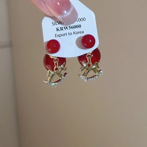 Détails de boucles d'oreilles en argent avec perles rouges et pendentifs cheval à bascule
