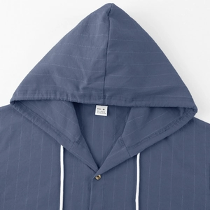 Close-up of a blue striped linen shirt neckline with hoodie drawstring and size label