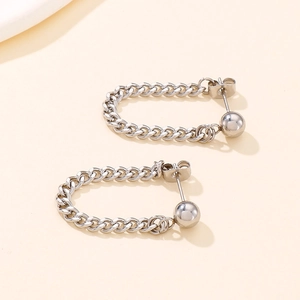 Close-up of silver steel U-shaped Cuban chain earrings with polished bead detail