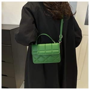 Detail of green square handbag with 3D plaid texture and gold hardware on model