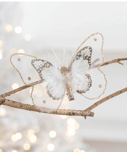 Close-up of white mesh butterfly ornament with gold glitter and soft feather detail