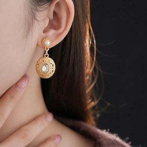 Macro detail of vintage gold earrings with pearls and crystals on a model