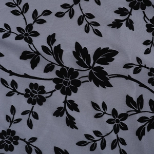 Macro shot of black floral flocking on gray-purple mesh fabric showing texture