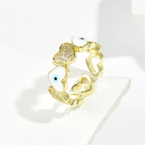 Golden open heart ring featuring evil eye enamel and cubic zirconia on a stone stand