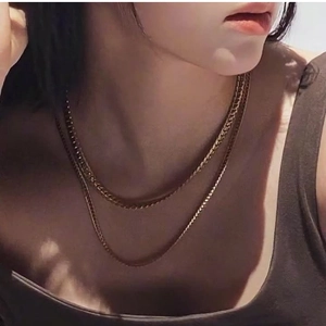 Close-up of double-layered gold stainless steel chain necklace worn by a female model