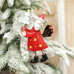 Handcrafted metal Santa Claus ornament hanging on a snowy Christmas tree branch