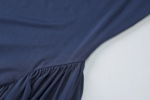 Close-up of navy blue knitted fabric with detailed ruching and pleated stitching