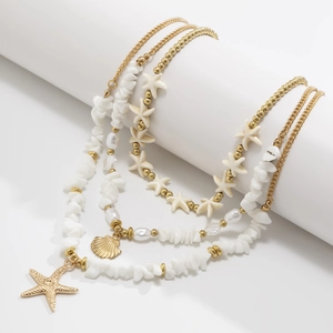 Detail of bohemian layered necklace with gold starfish, seashell charms and white pearls