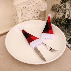 Red and black plaid Christmas mini hats silverware holders on white dinner plate