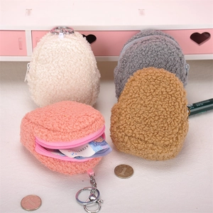 Close-up of plush coin purses in beige, pink, brown, and grey with zipper and keychain hooks