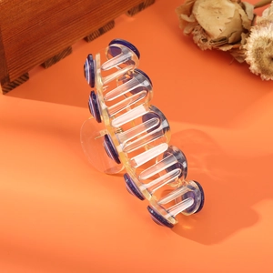 Quirky orange pumpkin hair claw clip with blue circular accents on orange backdrop