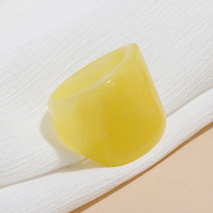 Macro shot of a chunky translucent yellow resin ring with a polished minimalist design